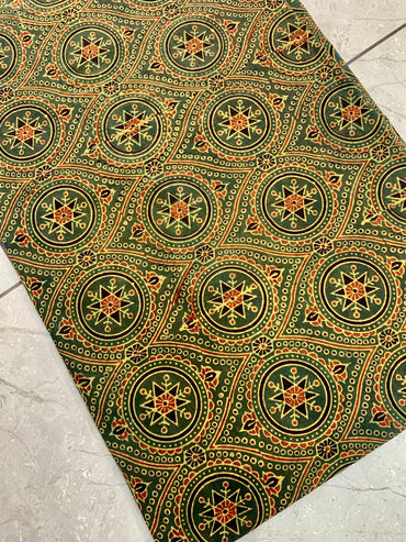 Green pure cotton Ajrakh fabric wholesale featuring heritage geometric patterns handprinted using natural dyes.