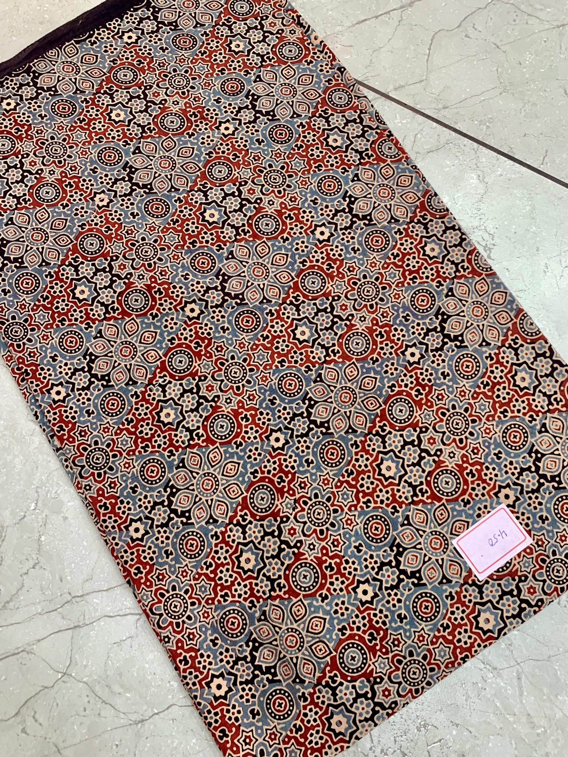 Black and maroon Ajrakh pure cotton wholesale fabric printed with heritage block patterns in deep natural dyes.