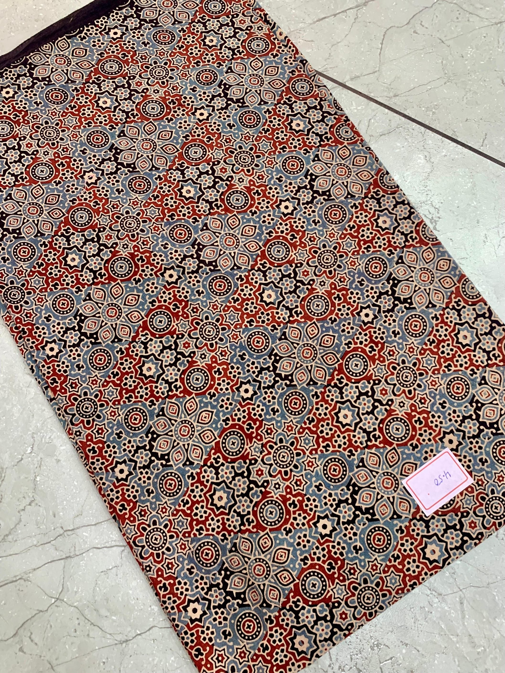 Black and maroon Ajrakh pure cotton wholesale fabric printed with heritage block patterns in deep natural dyes.