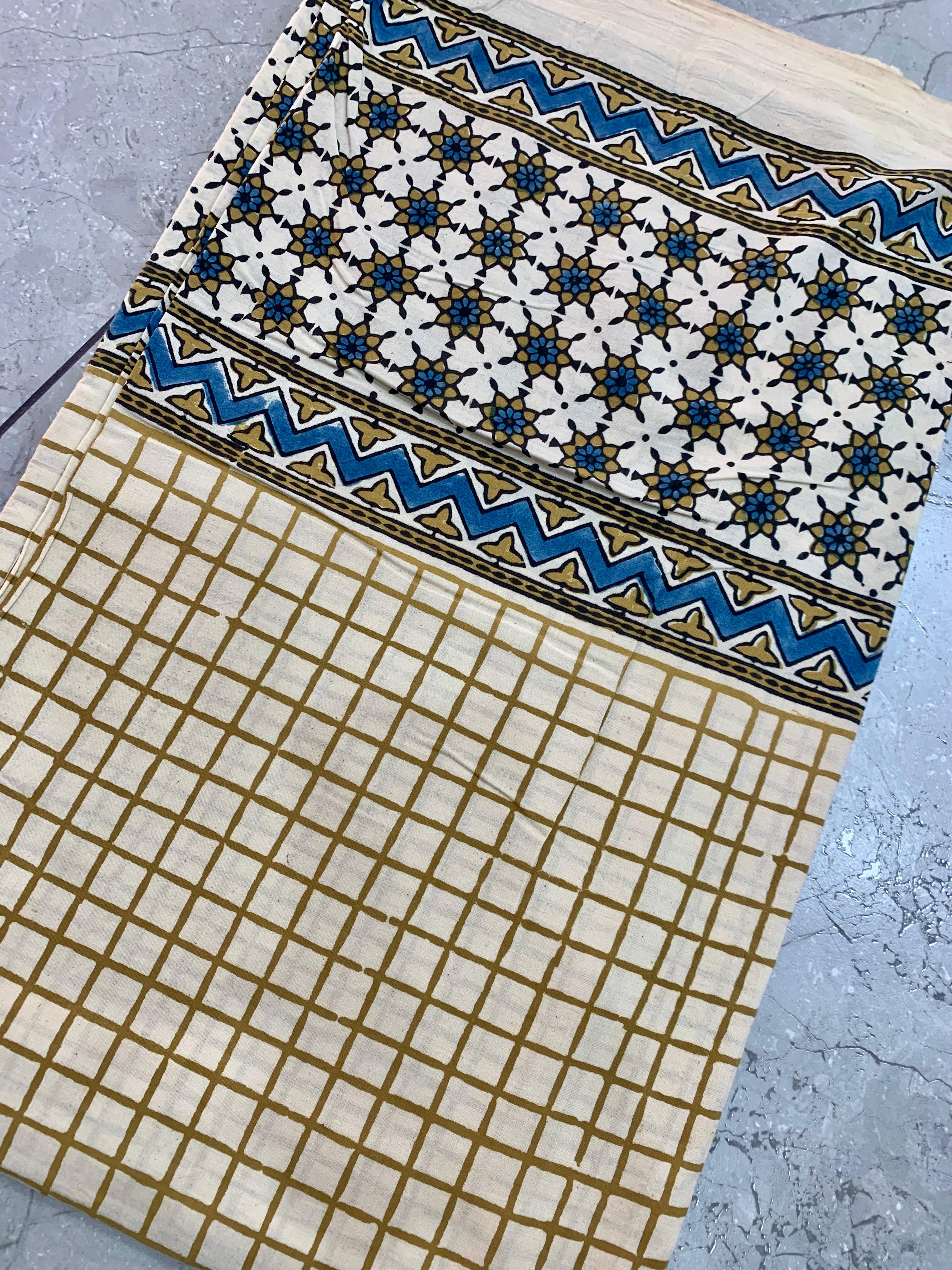 Cream Ajrakh pure cotton wholesale fabric with contrast artisan-printed borders and traditional motif work.