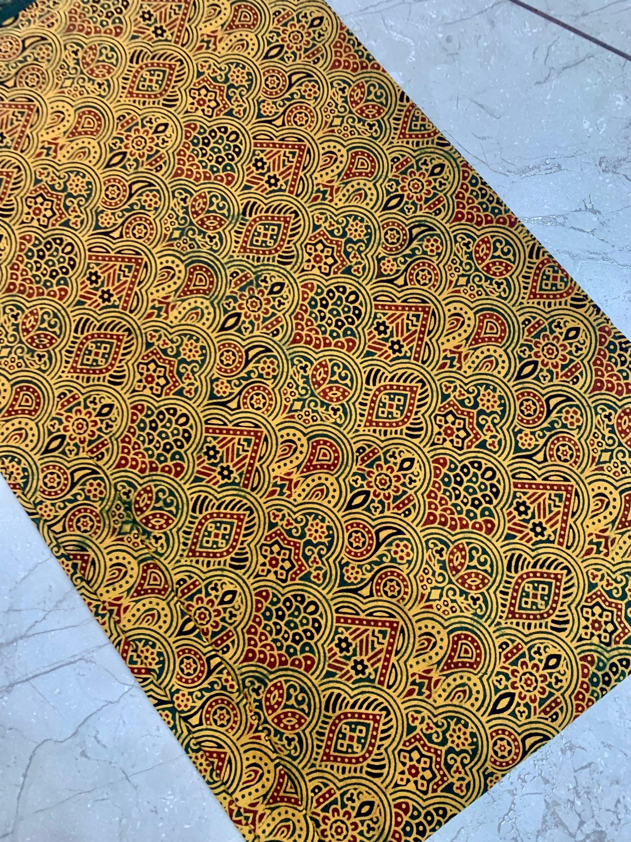 Mustard Ajrakh pure cotton fabric wholesale dyed using natural colors and printed with ethnic artisan motifs.