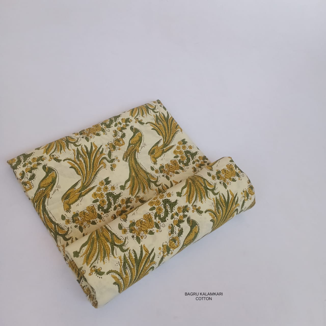Cream and green Bagru handblock printed pure cotton fabric featuring bird motifs, handmade textile perfect for boutique sourcing.