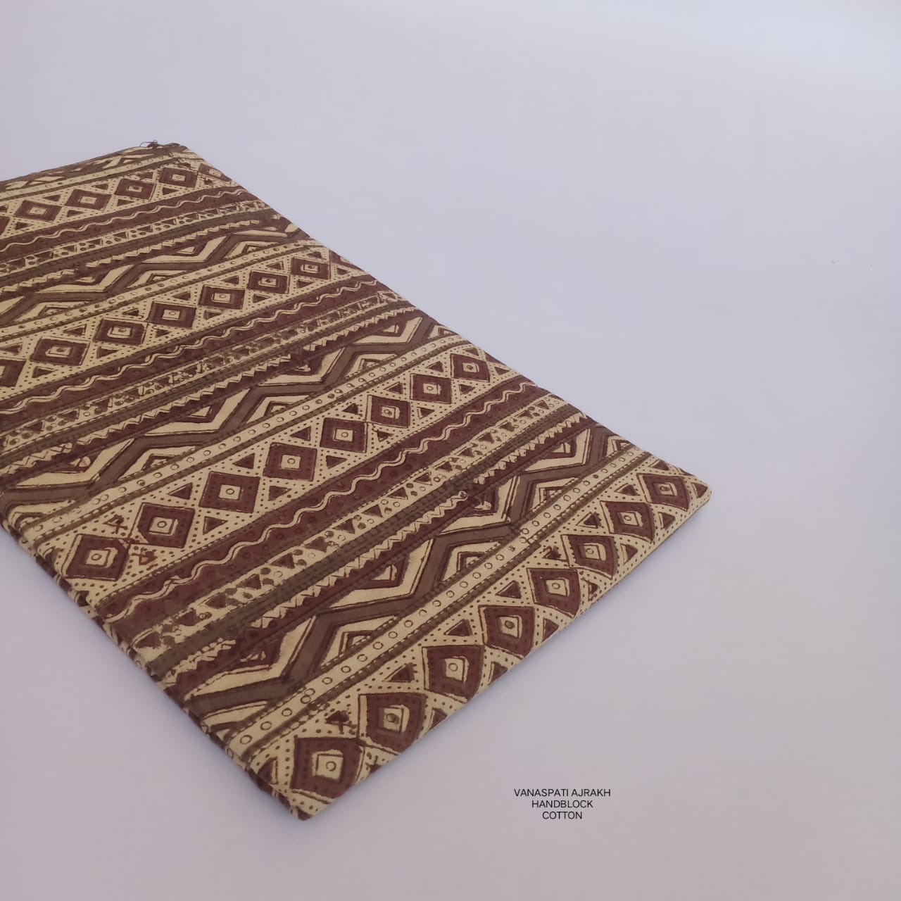 Geometrical Vanaspati pattern Bagru handblock printed pure cotton fabric in cream, naturally dyed and crafted for Fabtexs wholesale.