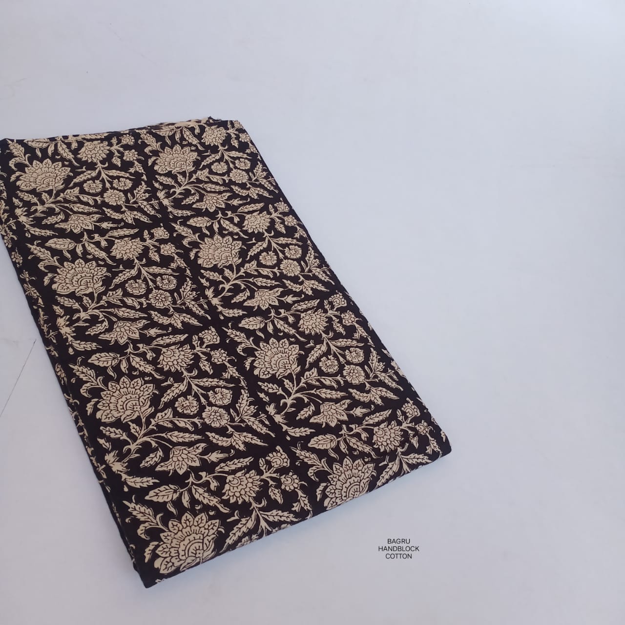 Black floral jaal Bagru handblock printed cotton fabric, naturally dyed and crafted for Fabtexs wholesale buyers and designers.