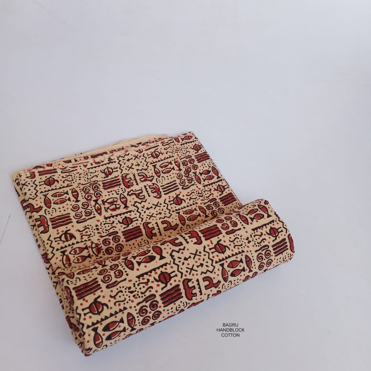 Cream and red Bagru handblock printed pure cotton fabric with Warli tribal motifs, handmade for artistic apparel designs.