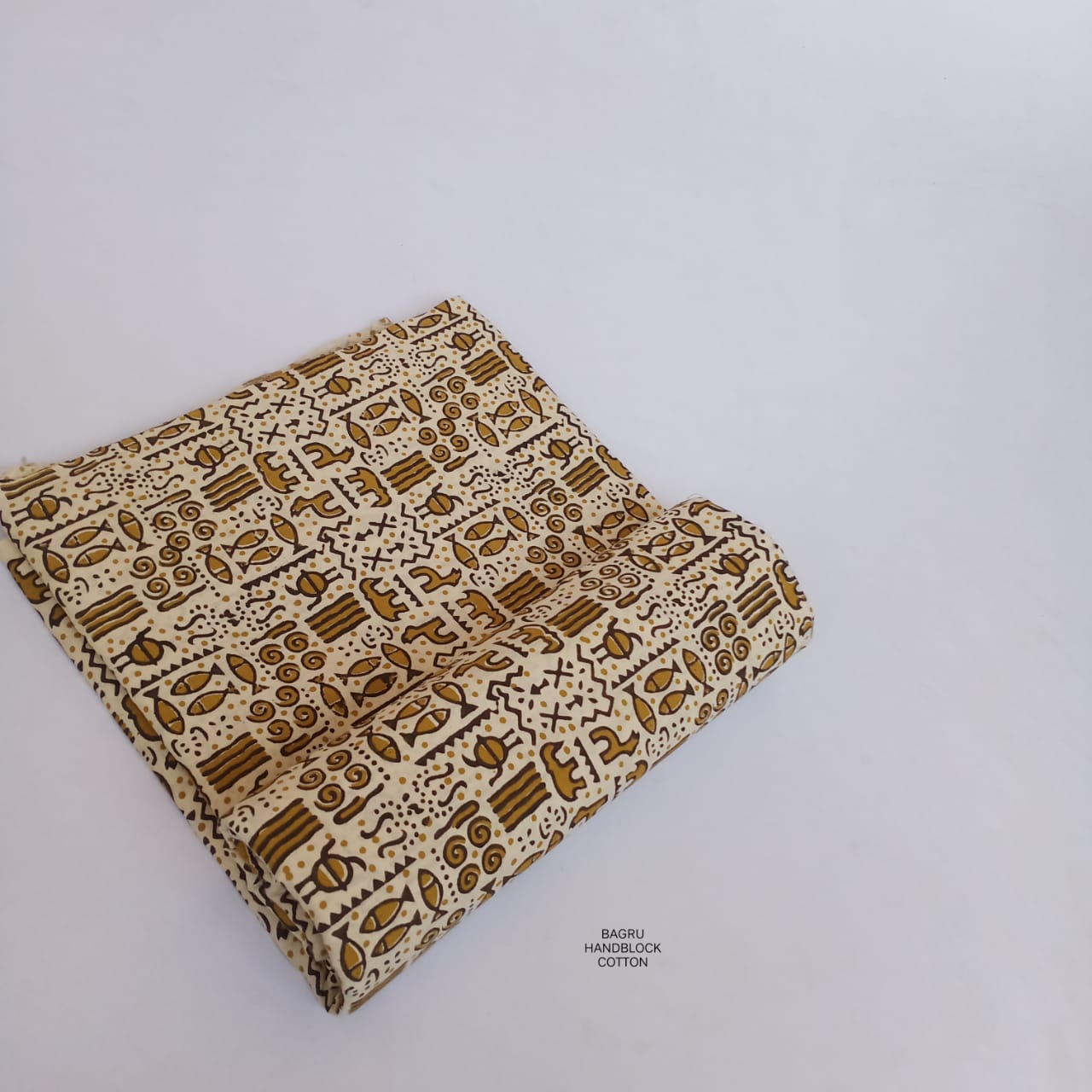 Cream and yellow Bagru handblock printed pure cotton fabric with traditional motif work, artisan dyed for boutique collections.