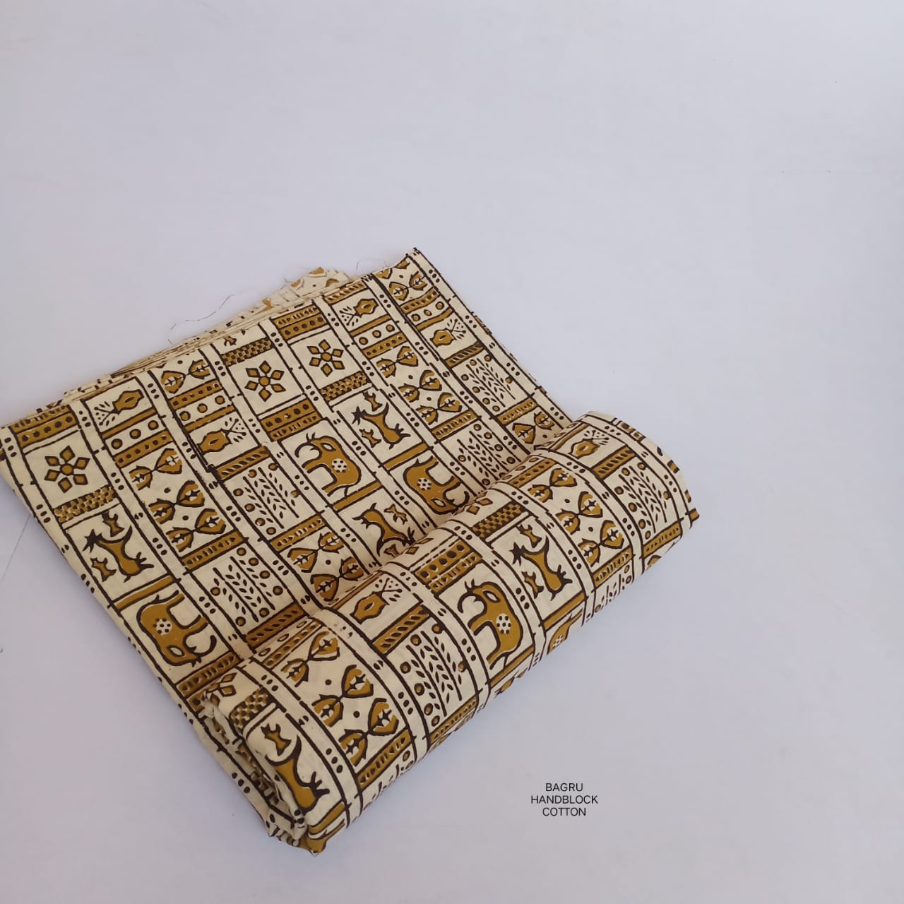 Cream and yellow Bagru handblock printed pure cotton fabric with Warli motifs, naturally dyed and handmade by Rajasthan artisans.