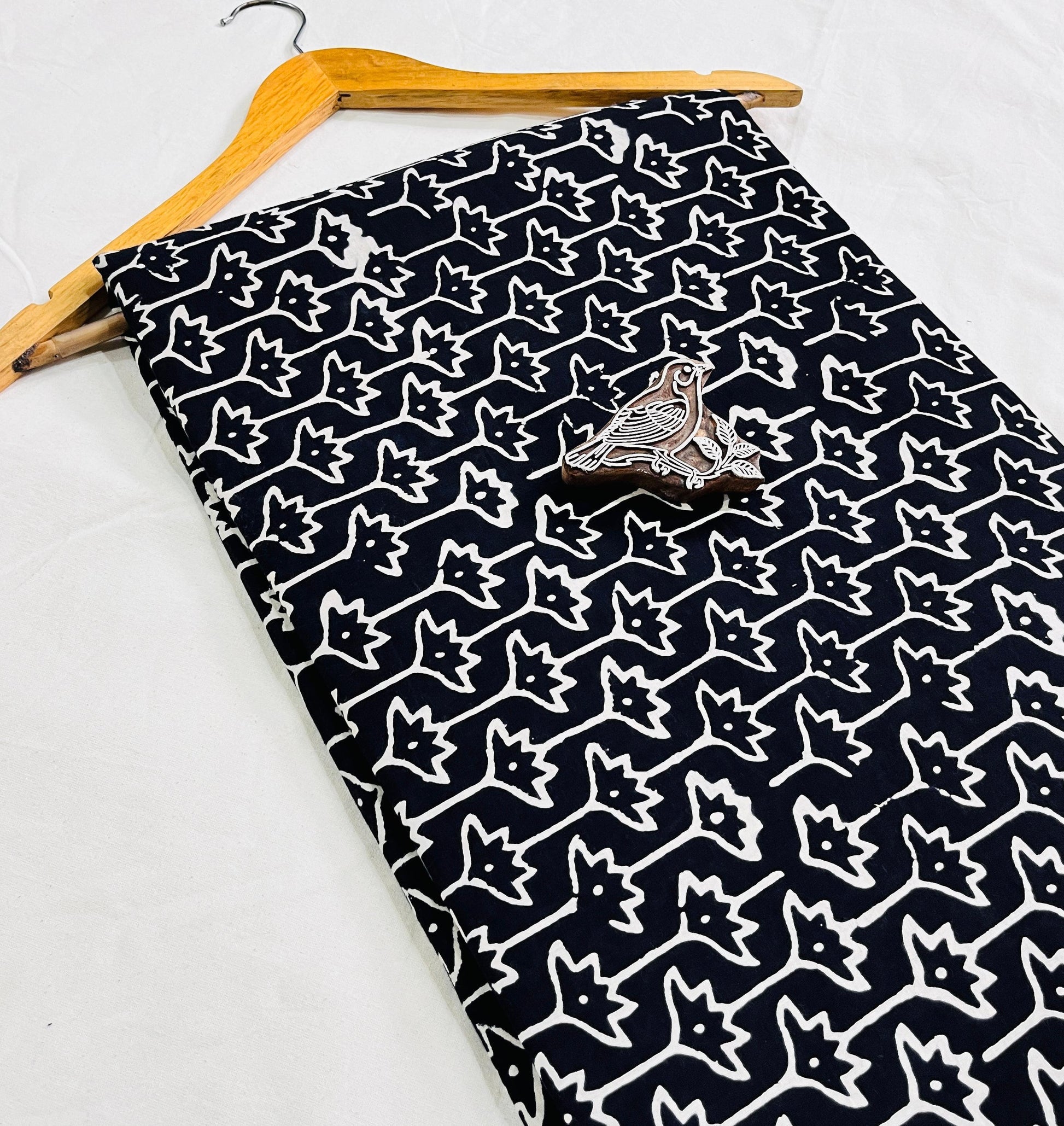 Black star-motif Dabu mud-resist printed pure cotton fabric, sustainable and artisan-crafted for bulk wholesale orders via Fabtex.