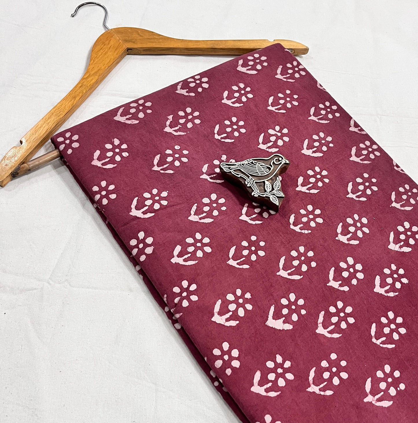 Maroon natural-dyed pure cotton Dabu handblock print fabric, handcrafted for boutique wholesalers.